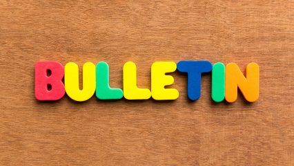 Colorful letters spell "Bulletin" on wood background