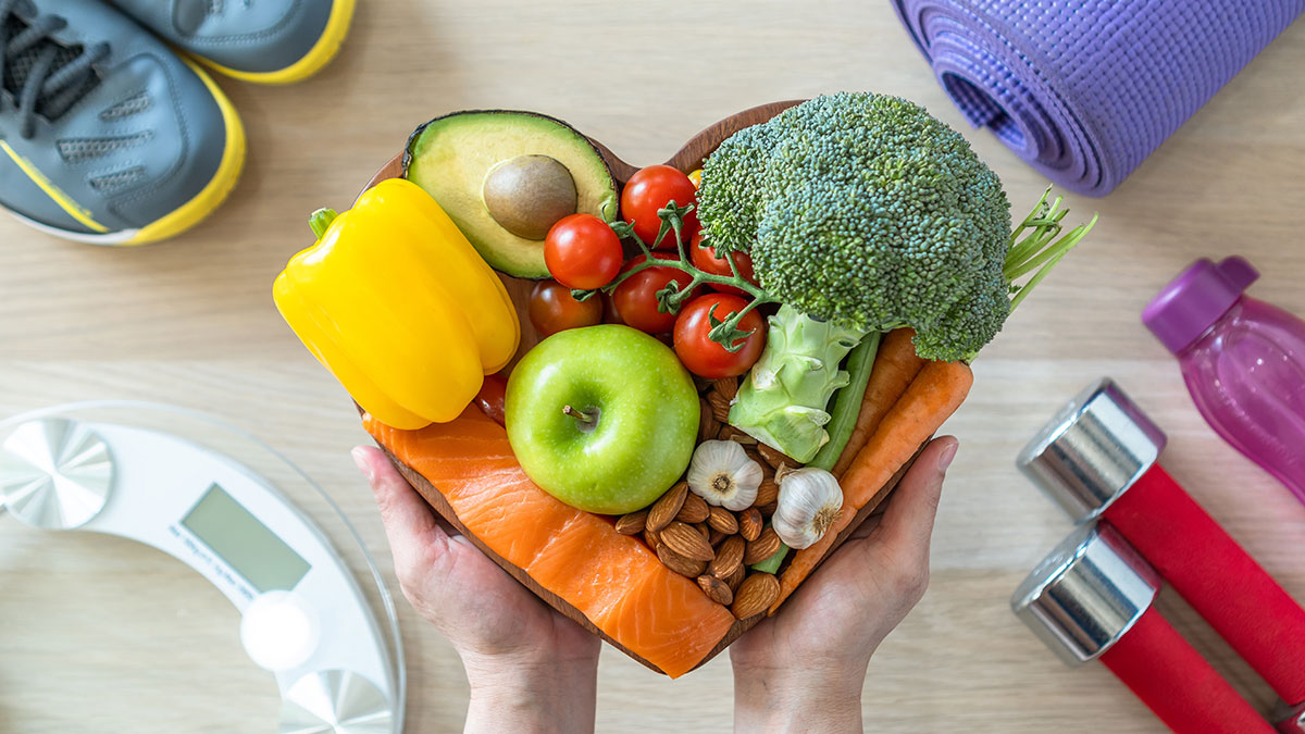 A heart-shaped plate holding assorted fruits and vegetables