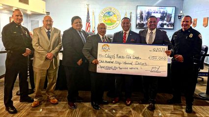 Supervisor Baca, Jr with representatives from the City of Rialto Fire Department holding a large check