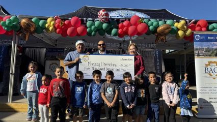 Supervisor Joe Baca, Jr. presenting Muscoy Elementary School Principal and students with $5,000 at 2025 Toy Giveaway