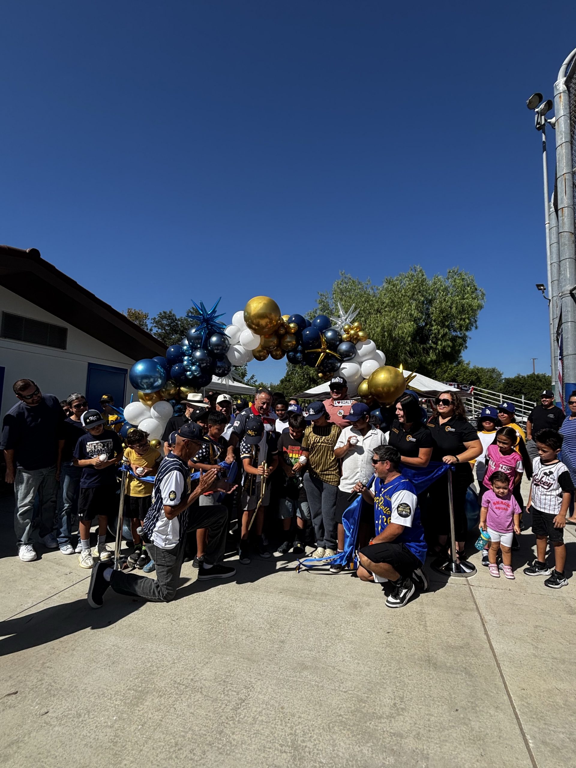 Supervisor Joe Baca, Jr. Fifth District Commissioners, City of Rialto Council Members, and representatives of North Rialto Little League cutting the ribbon for the Birdsall Park Snack Bar